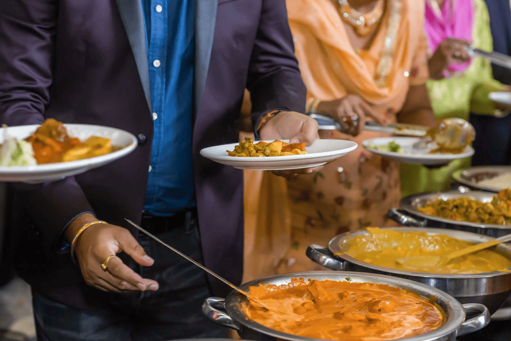 Guests enjoying a meal at an Indian catering event.