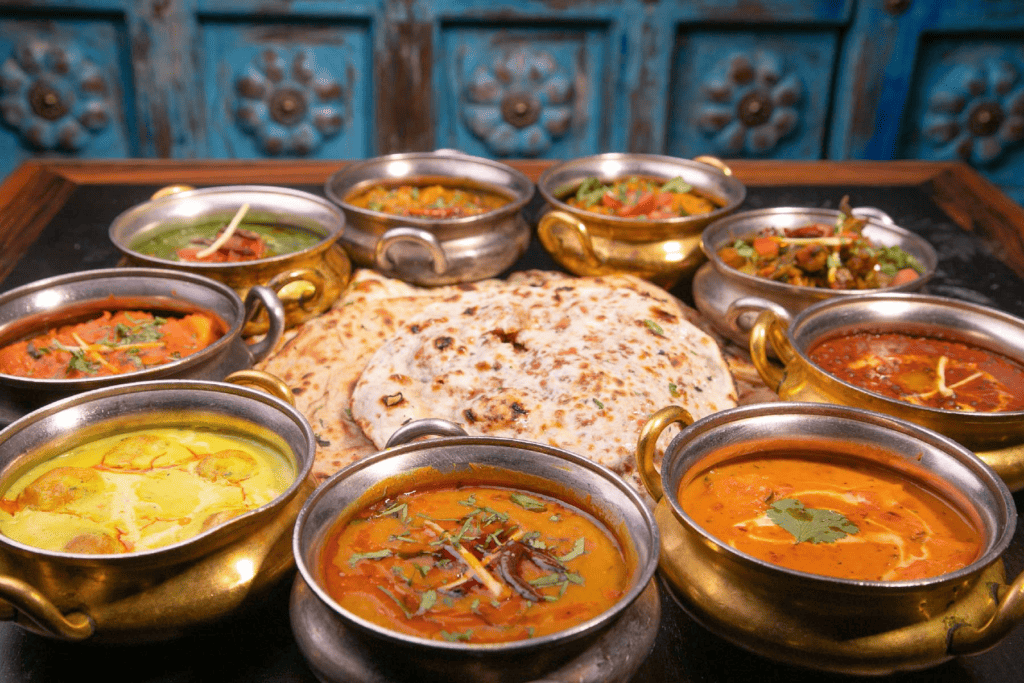 Assortment of Indian dishes, including creamy curries and freshly baked naan.